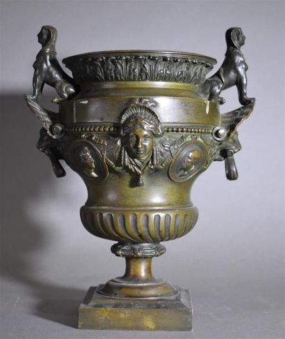 Petit vase en bronze patiné à décor de masques...