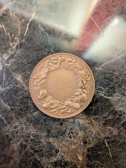 Medal representing three putti
In its ca...