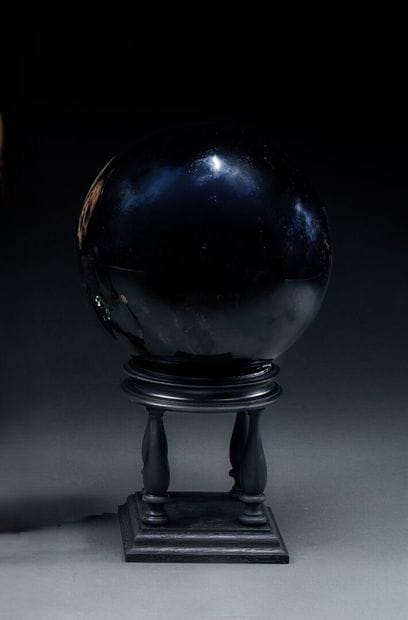 Black crystal divination ball on a four-legged...