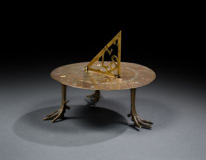 Curious brass sundial resting on three bird...