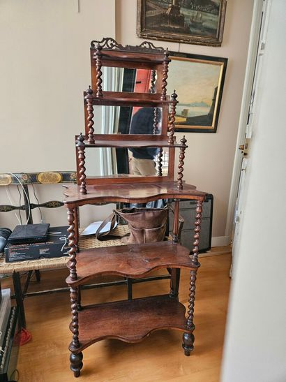A mahogany shelf with an undulating shape,...