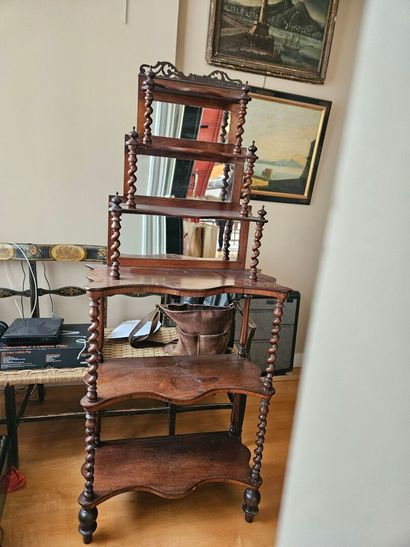 A mahogany shelf with an undulating shape,...
