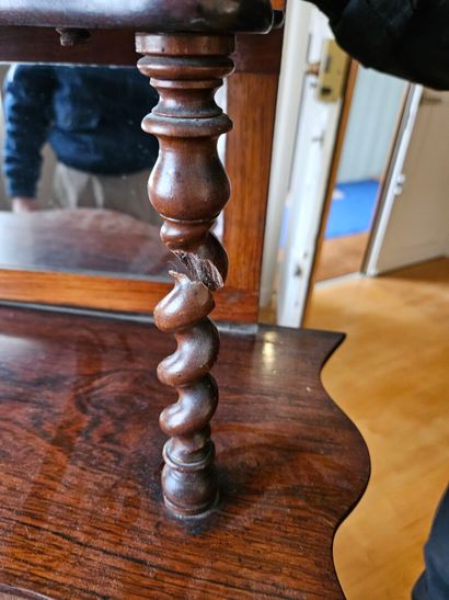 A mahogany shelf with an undulating shape,...