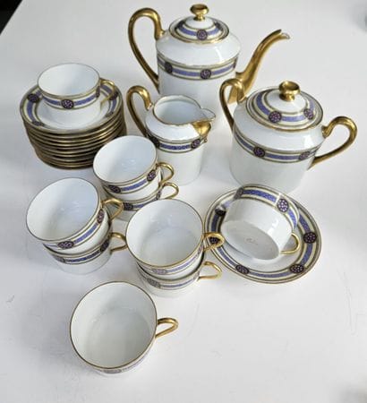 A white and gold porcelain coffee set decorated...