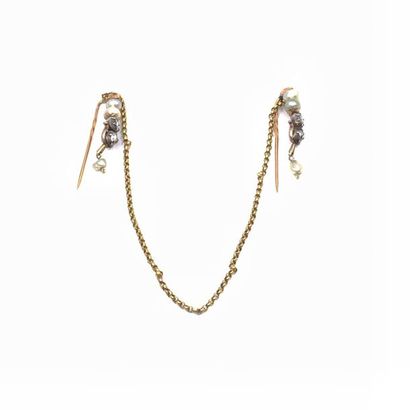 TWO tie pins linked by a 750 ° yellow gold...