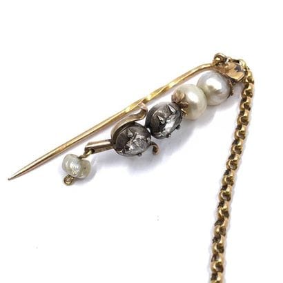 TWO tie pins linked by a 750 ° yellow gold...