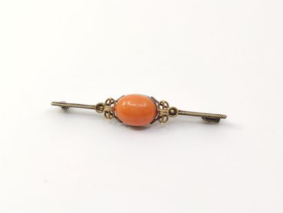 Gold and silver pin set with a coral cabochon...