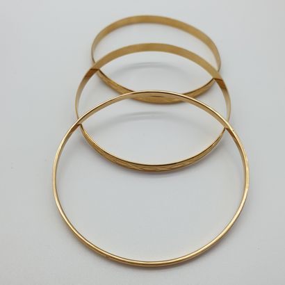 TROIS bracelets en or jaune 750° joncs ciselé

Poids...