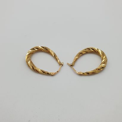 Pair of oval twisted CREOLES in yellow gold...