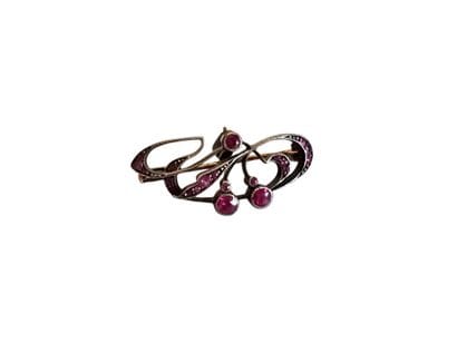 BROCHE en or et argent ornée de rubis 
Poids...