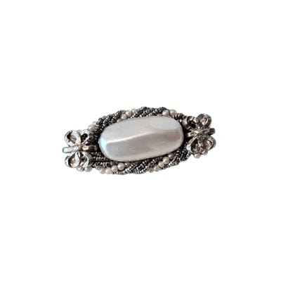 BROCHE en métal de forme oblongue à décor...