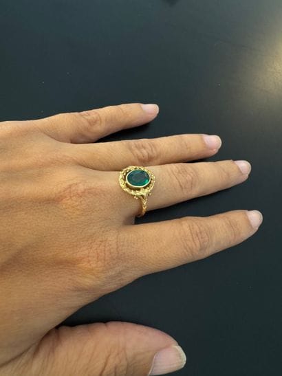 A yellow gold (.750) ring featuring an oval...