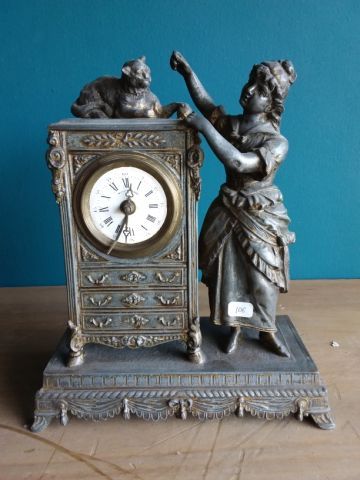 PENDULE en métal représentant la mère Michèle...
