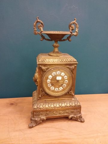 PENDULE en bronze doré surmonté d'une coupe,...