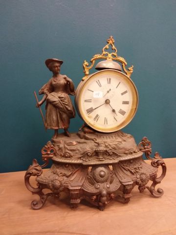 PENDULE en métal, à décor de bergère, le...