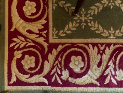 Tapis en laine à fond vert et bordure rouge...