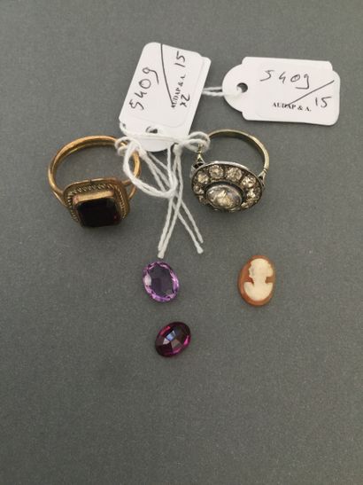 Two metal rings set with red and white stones.

Two...