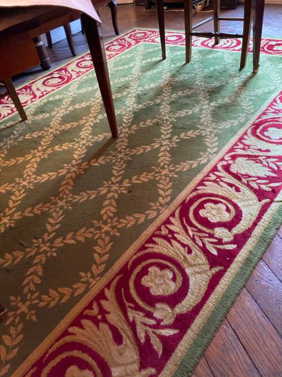 Tapis en laine à fond vert et bordure rouge...