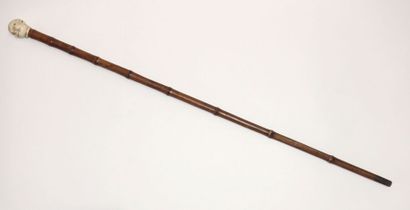 Wooden cane (bamboo?), the pommel in carved...