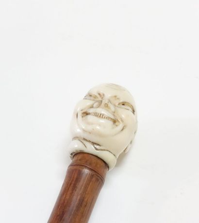 Wooden cane (bamboo?), the pommel in carved...