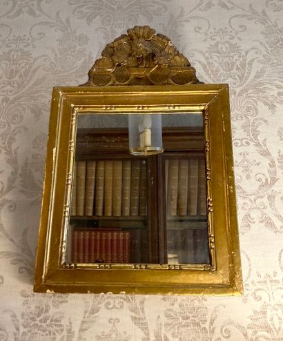 Petit miroir en bois doré et sculpté, le...