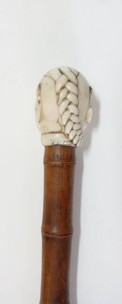 Wooden cane (bamboo?), the pommel in carved...