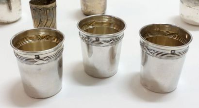 A set of seven small silver cups of various...