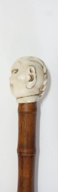 Wooden cane (bamboo?), the pommel in carved...