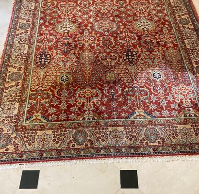 Tapis en laine et soie à fond rouge et bordure...