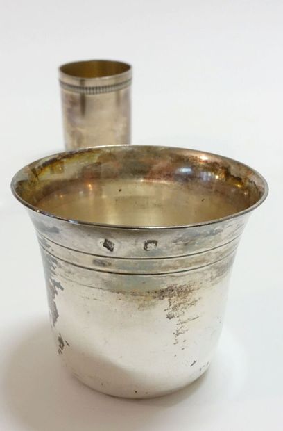 A set of seven small silver cups of various...