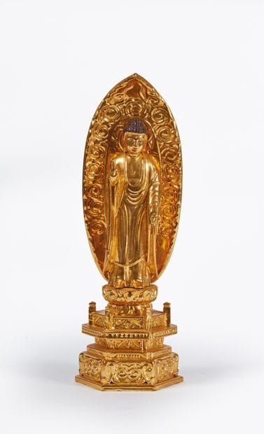 Statuette of Buddha standing, in front of...