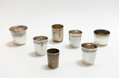 A set of seven small silver cups of various...