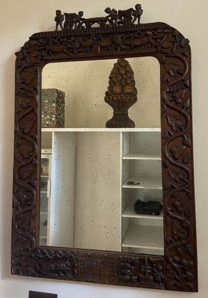 Miroir dans un cadre en bois sculpté cintré...