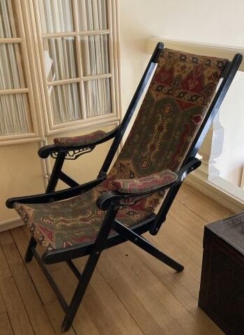 Fauteuil pliant en bois laqué noir, la garniture...