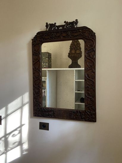 Miroir dans un cadre en bois sculpté cintré...