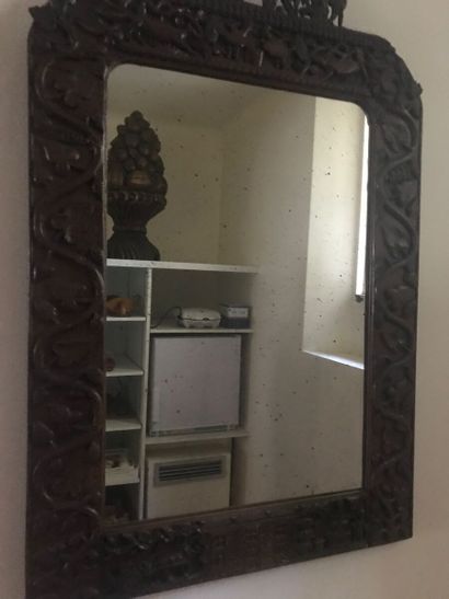 Miroir dans un cadre en bois sculpté cintré...