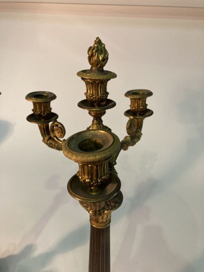 A pair of four-light patinated and gilt bronze...