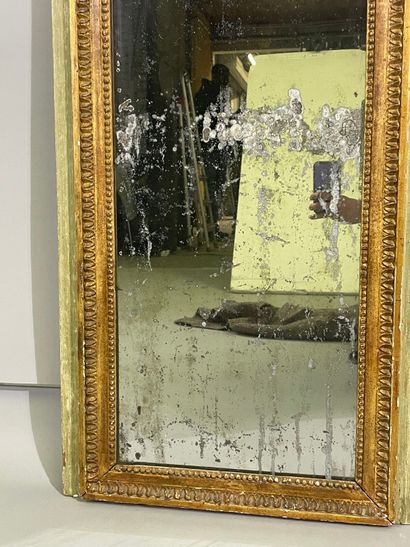 Overmantel mirror between two windows, the...