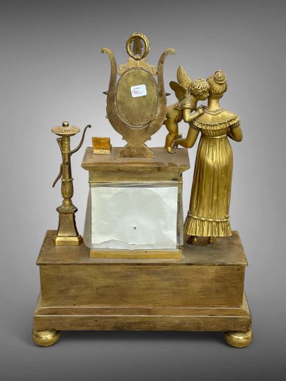 Pendule en bronze doré ornée d'un Amour murmurant...