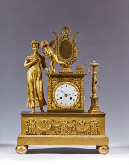 Pendule en bronze doré ornée d'un Amour murmurant...