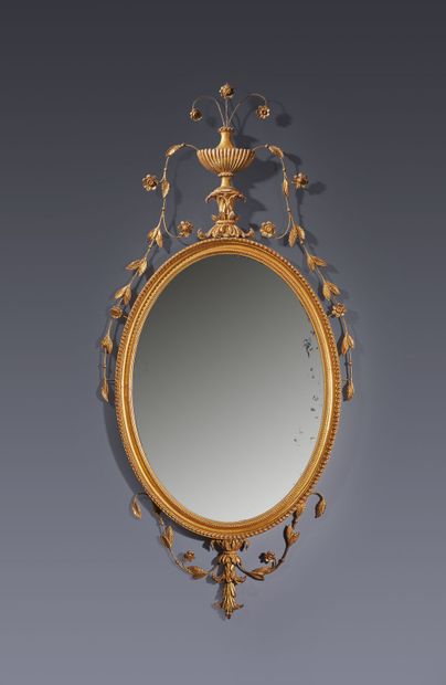Miroir ovale en bois et métal stuqué mouluré,...