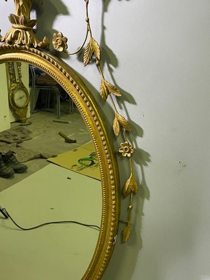 Miroir ovale en bois et métal stuqué mouluré,...
