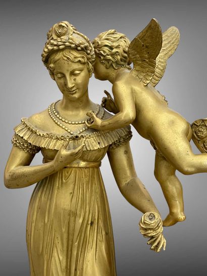 Pendule en bronze doré ornée d'un Amour murmurant...