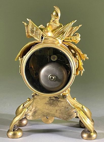 Pendule en bronze doré à décor de trophées...