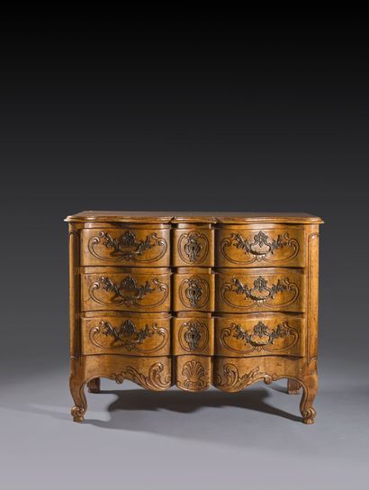 Commode en noyer mouluré et sculpté de forme...