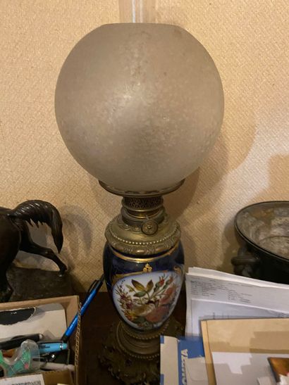Réunion de quatre lampes à pétrole en porcelaine...