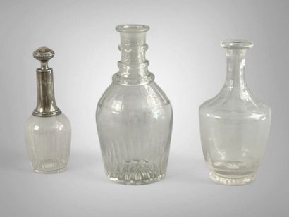 Réunion de trois carafes couvertes en verre,...