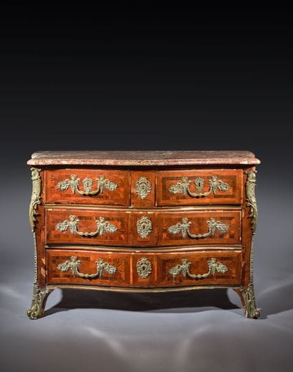 A rosewood chest of drawers with a curvilinear...