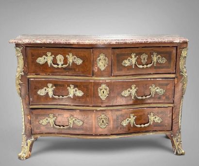 A rosewood chest of drawers with a curvilinear...