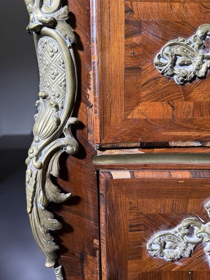 A rosewood chest of drawers with a curvilinear...